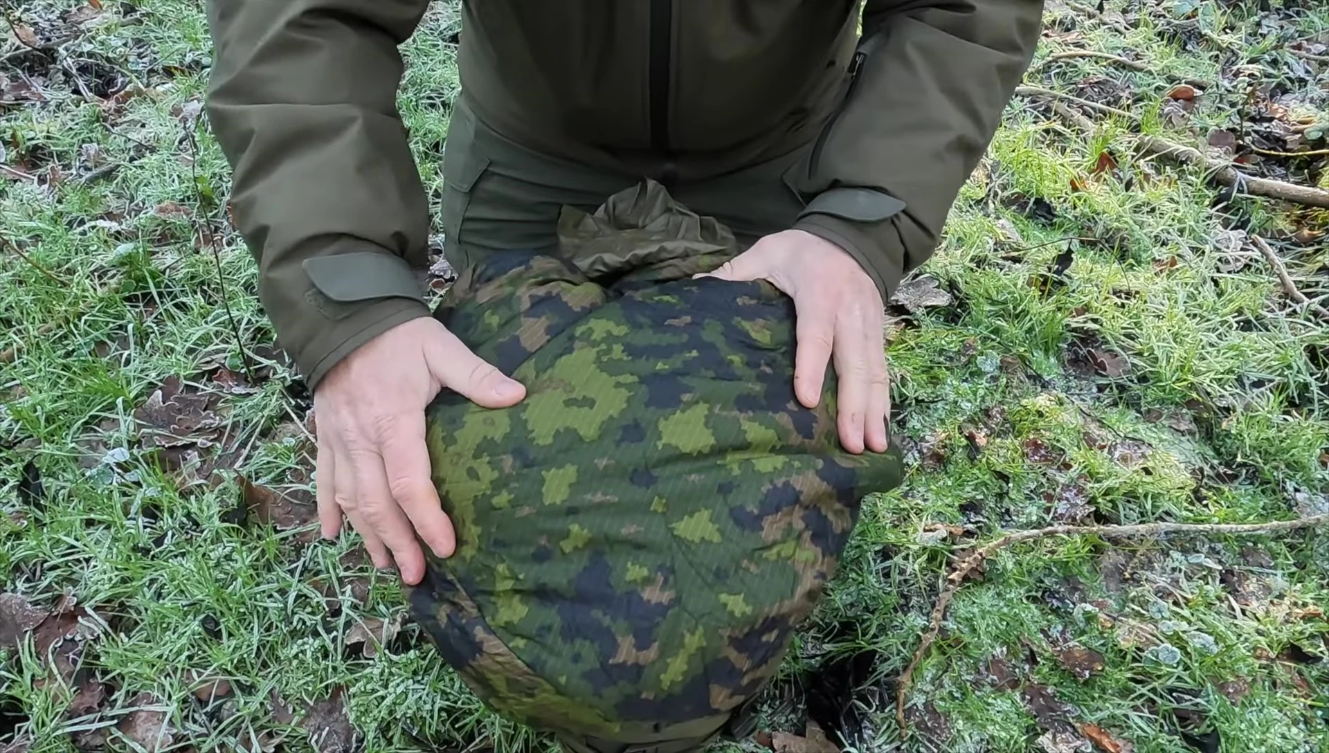 Showcasing the sleeping bag's camouflage pattern.