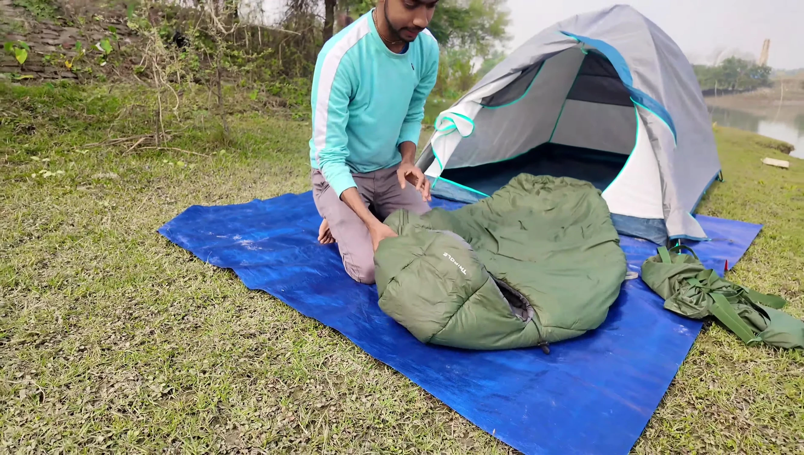Reviewer demonstrating the size of the sleeping bag compared to their height.
