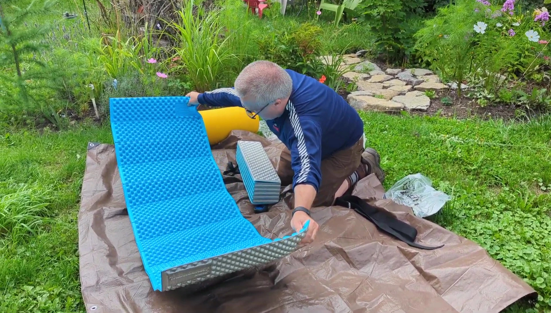 The reviewer demonstrates the length of the Therm-a-Rest pad.