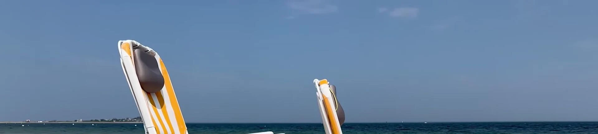 The reviewer comparing the seat height of the Shore Thing and Tall Sand Dune chairs.