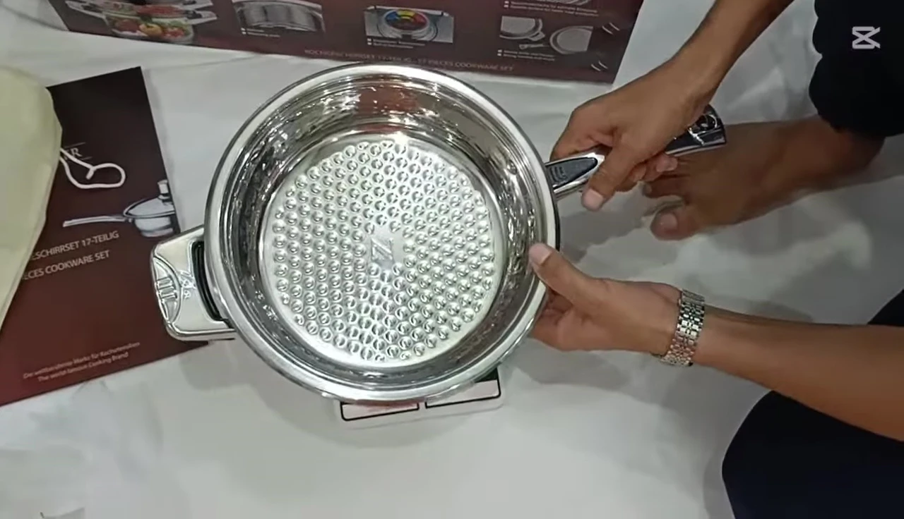 The empty frying pan being weighed on a scale, showcasing its weight.