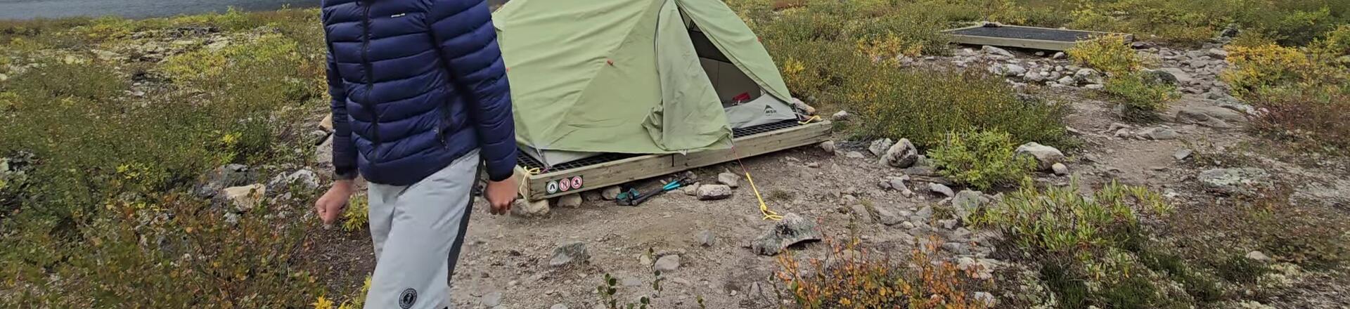 The reviewer highlights the two doors and ventilation features of the tent.