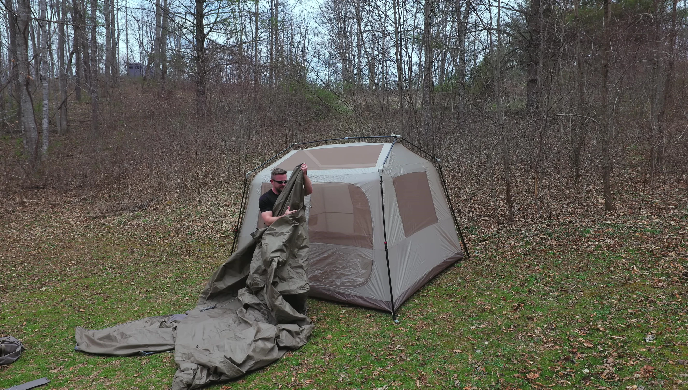 Person throwing the flysheet over the tent