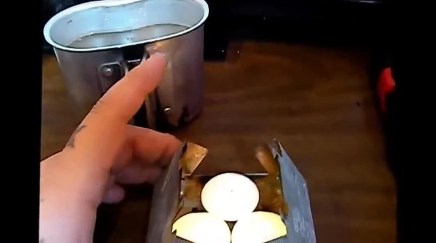 Three teacup candles arranged on the Esbit stove.