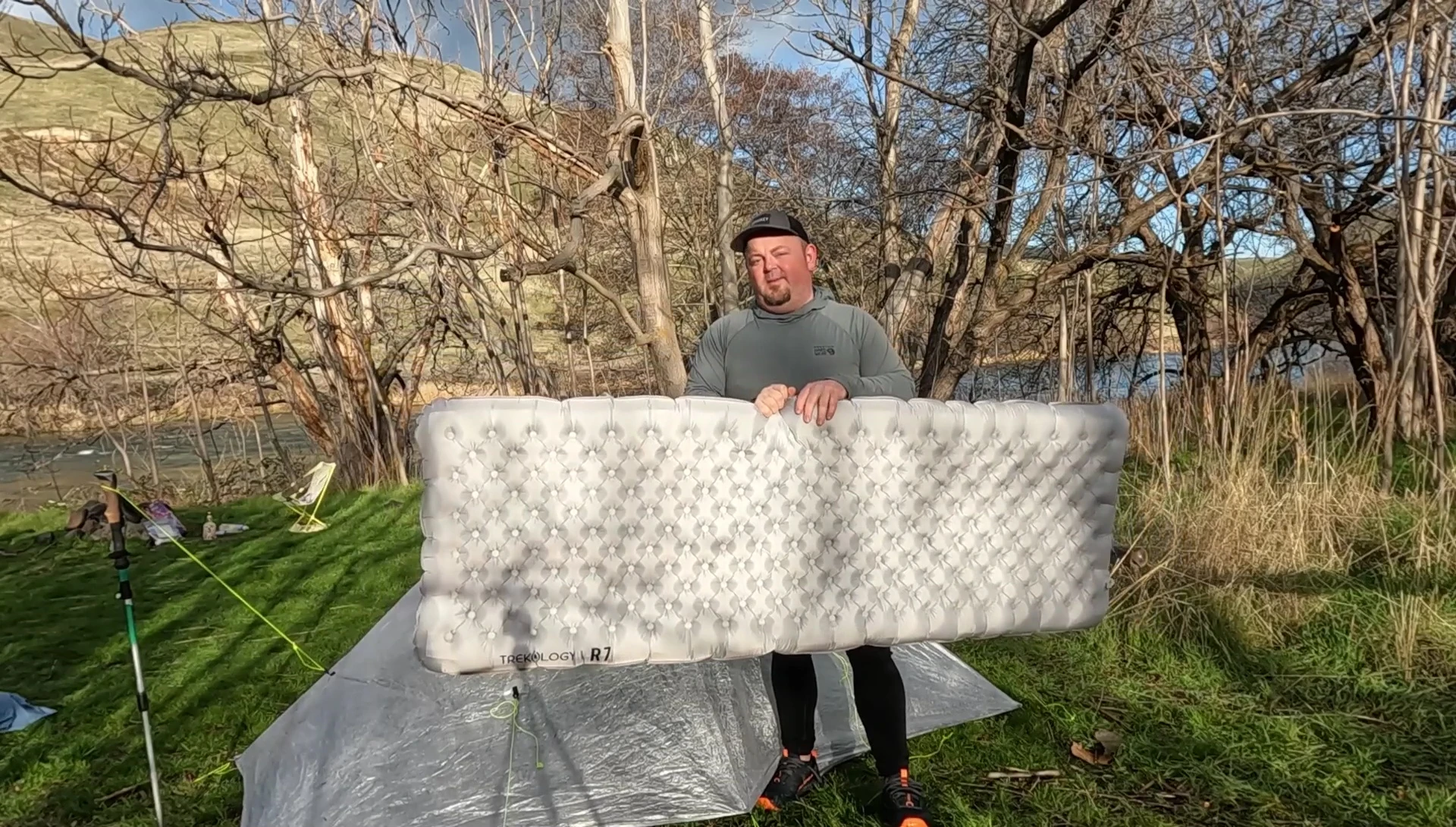 Shot demonstrating the packed size of the sleeping pad compared to two Nalgene bottles.