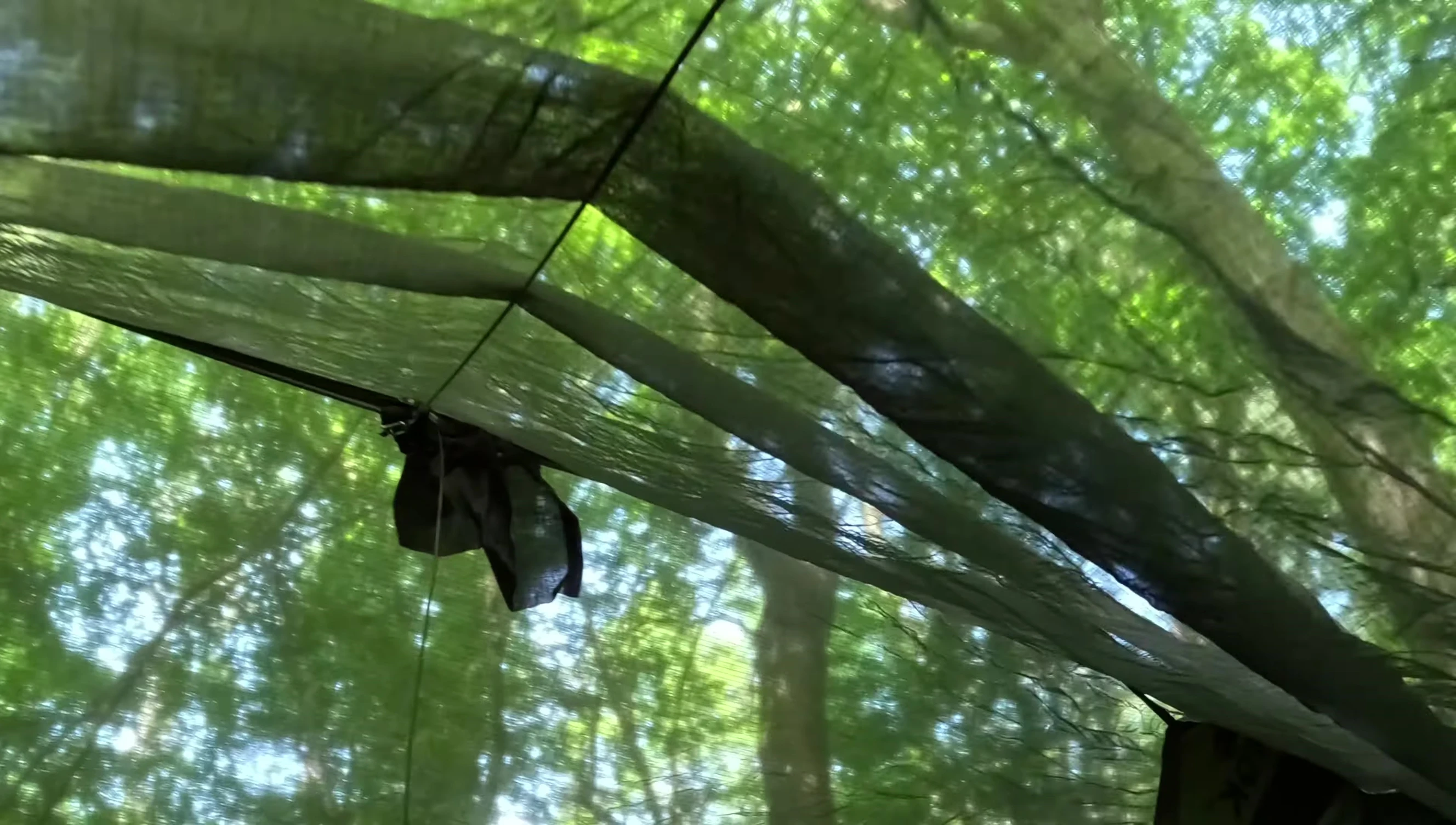 The user demonstrates the solution for raising the bug net using the additional string.