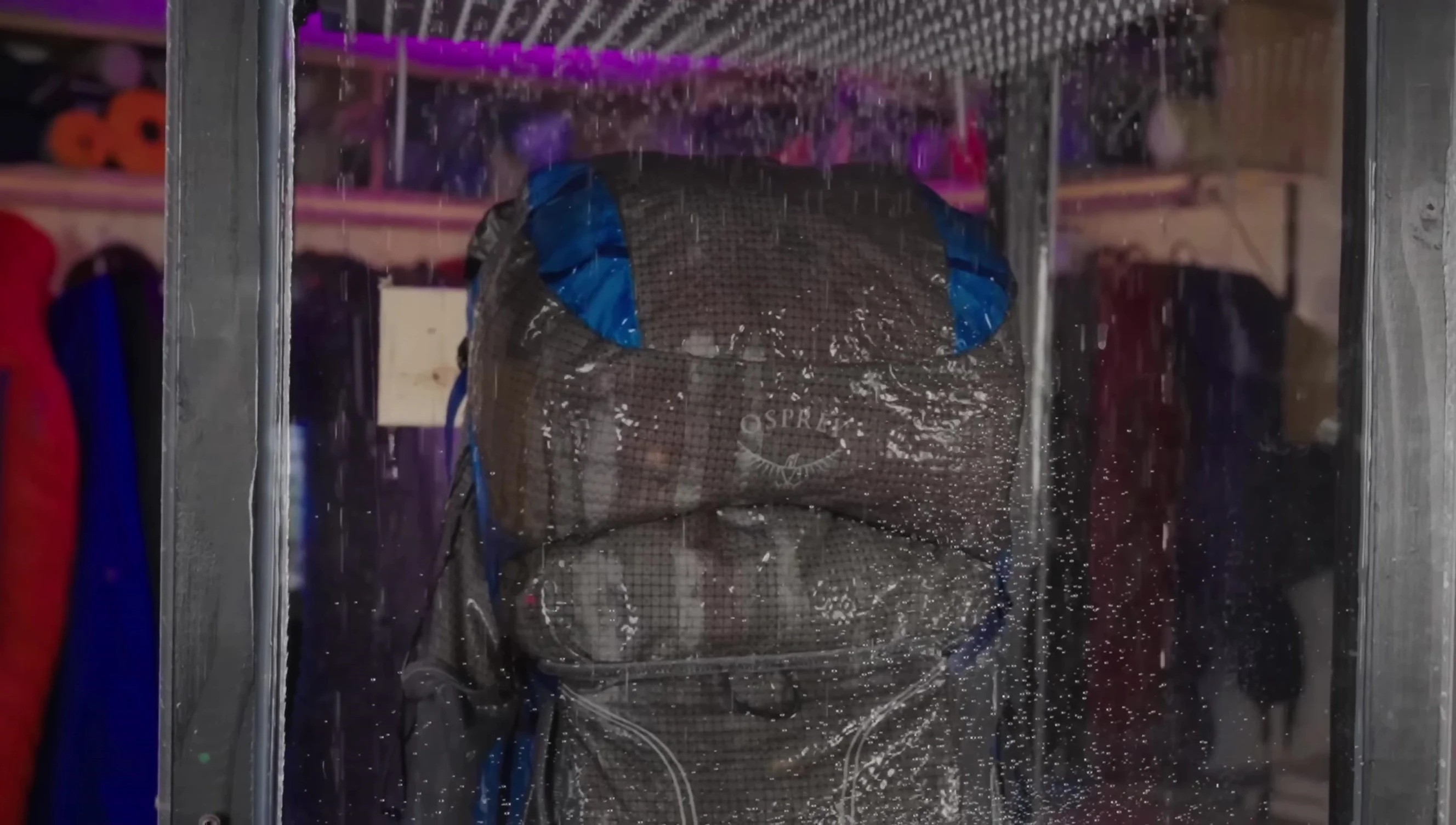 The down quilt placed in a backpack inside a rain chamber.