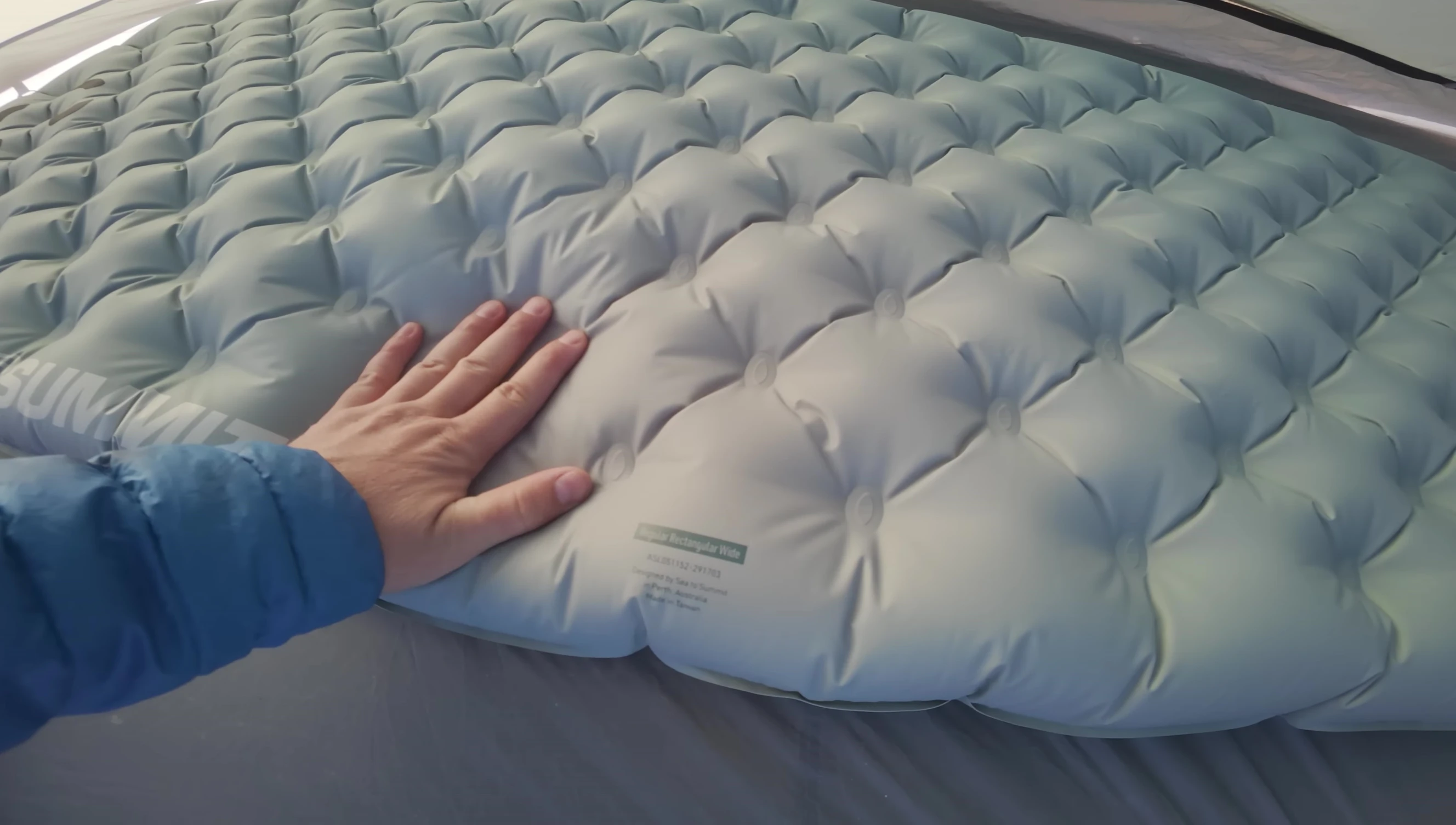Comparison of top materials of different sleeping pads, highlighting the stretchiness factor.