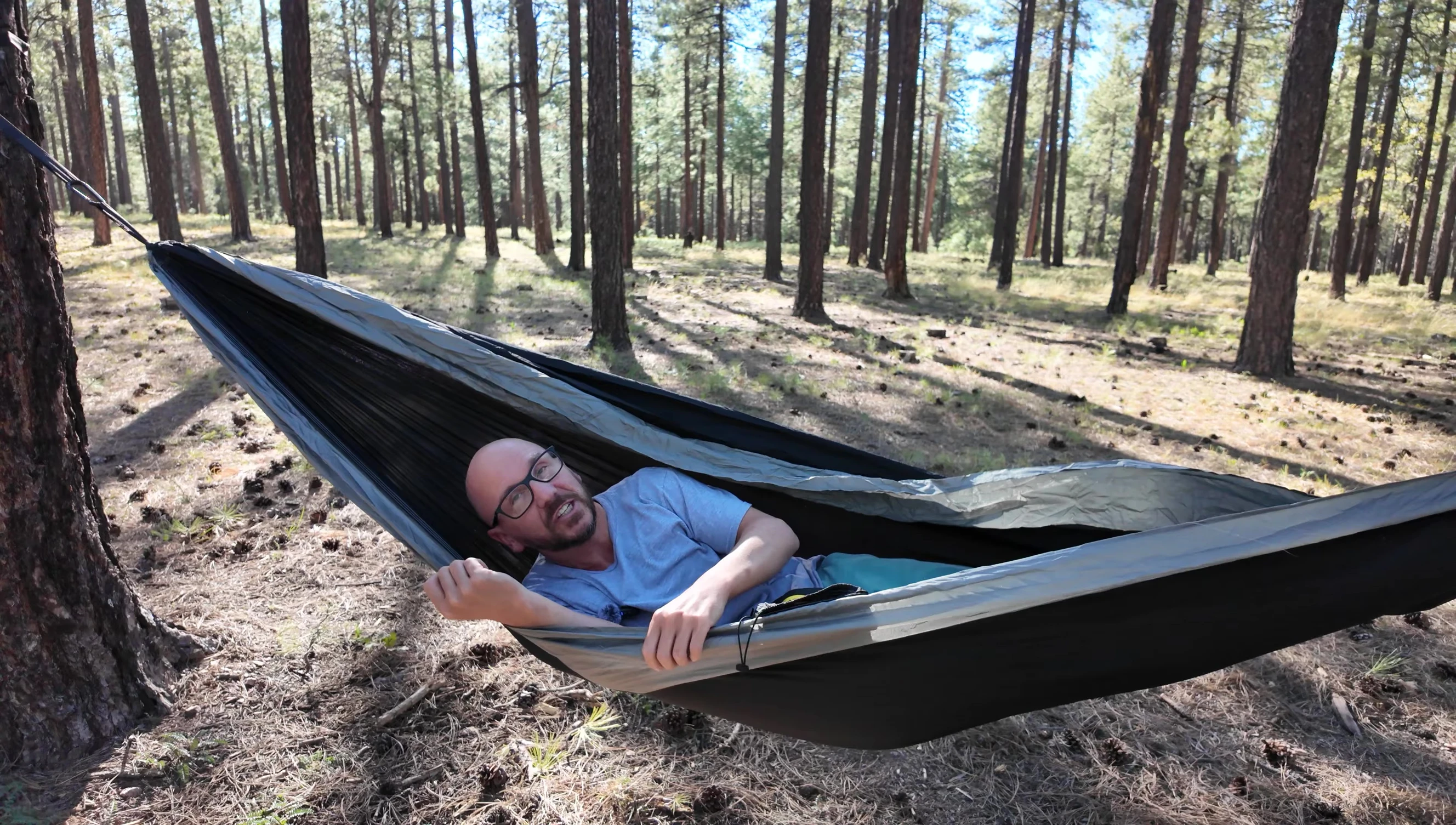 Person demonstrating the ability to sleep on their side in the hammock.