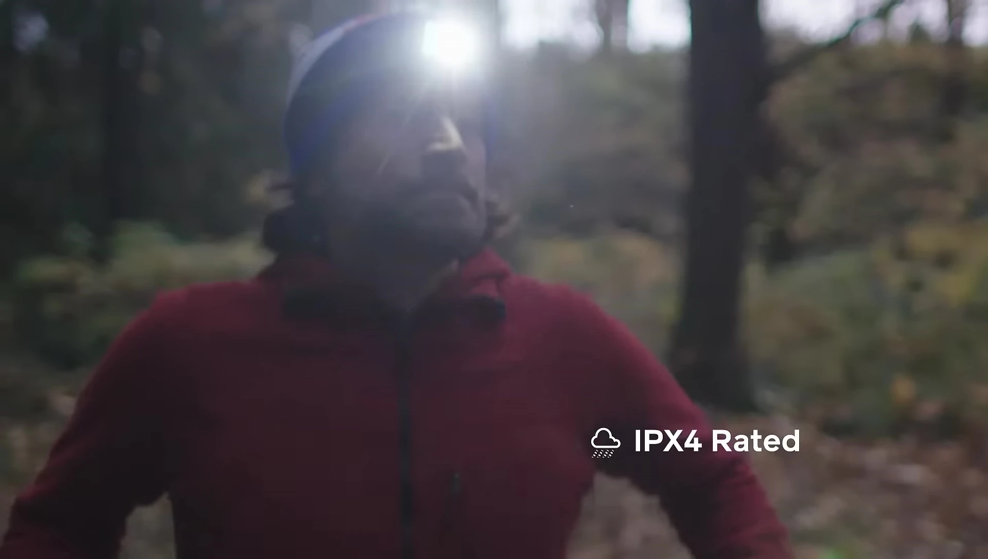 Headlamp in use during a rainy outdoor activity, demonstrating its weather resistance.