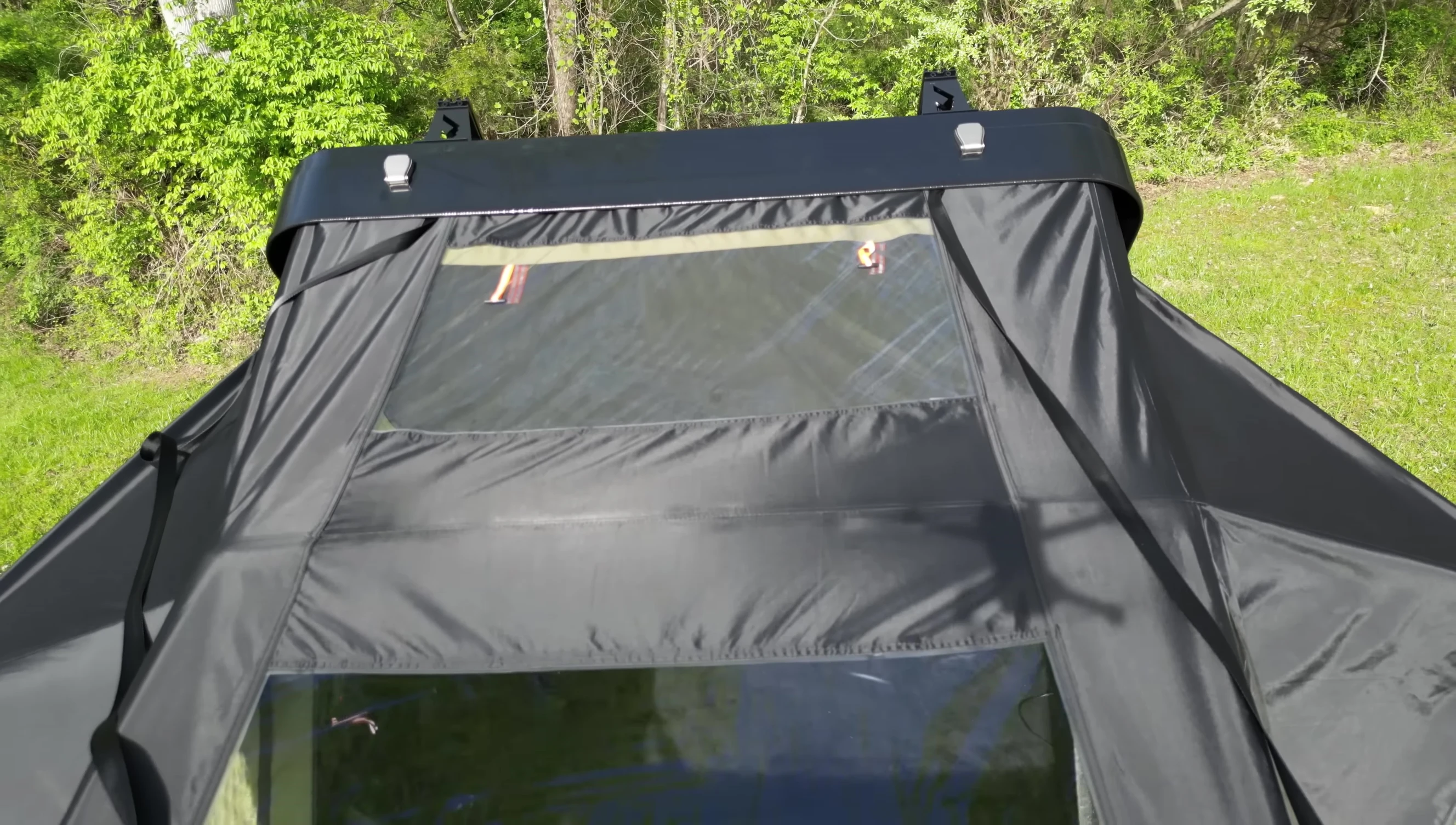 The reviewer sitting inside the tent while showcasing the skylight and awning.