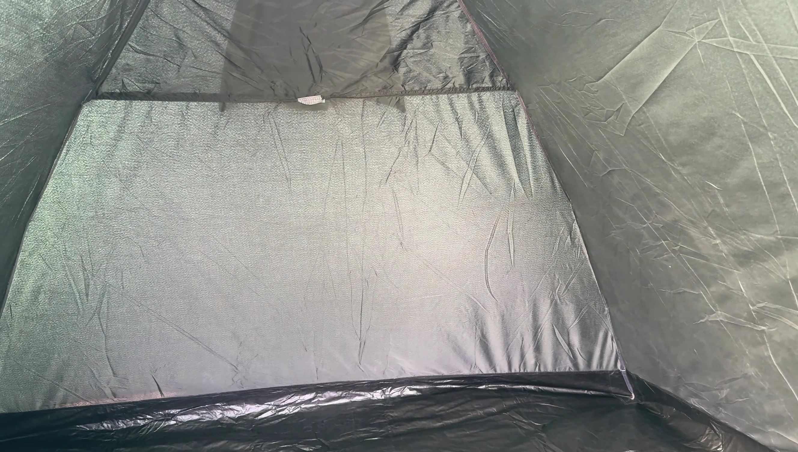 The reviewer highlighting the significant difference in light levels between the inner and outer tent areas due to the Nightfall material.
